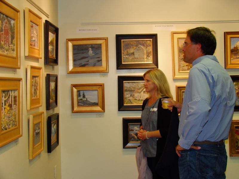 Artists Anne Blair Brown and Richard Oversmith pause over Stuart Roper's works.  LISA KRISTOFF/Boothbay Register